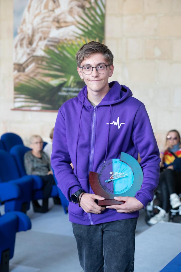 Jeune sportif avec le trophée des sport 2025