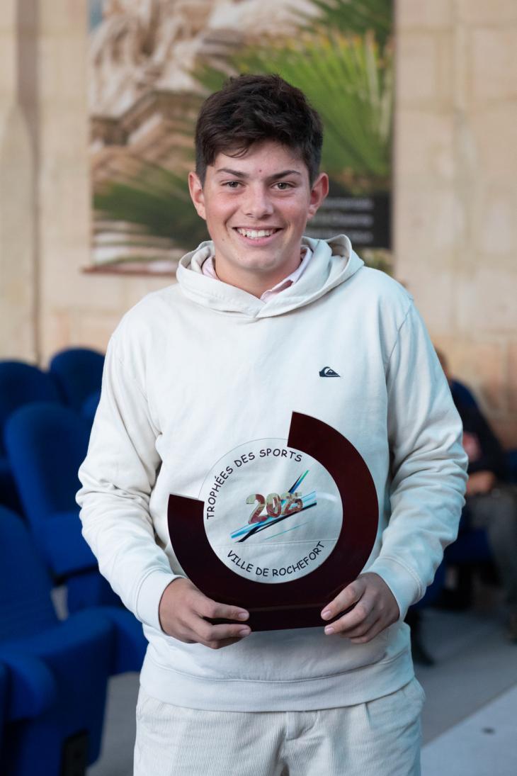 Jeune sportif avec le trophée des sport 2025