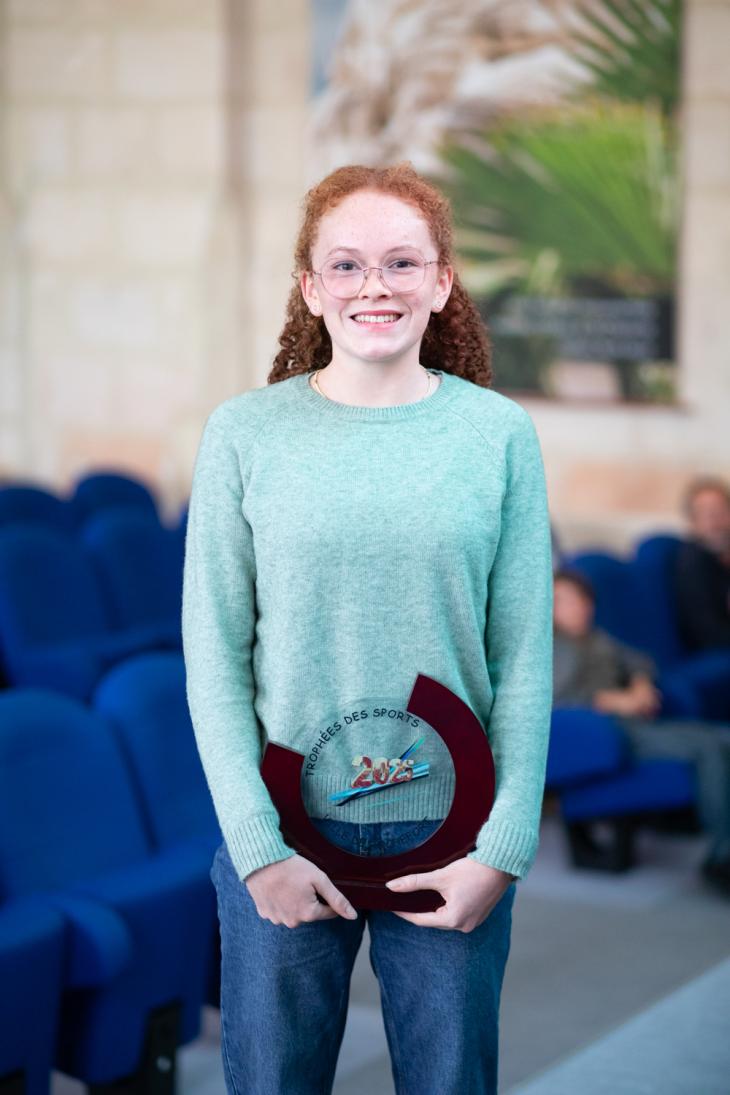 Jeune sportif avec le trophée des sport 2025